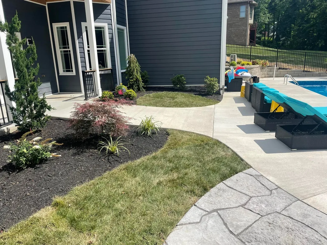 Concrete: a curved concrete walkway between a new mulch bed and a lawn