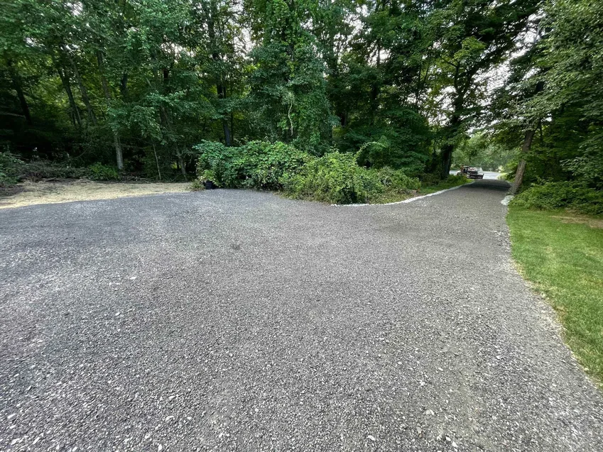 Gravel driveways: a finished crushed stone driveway with a wide turnaround on a wooded lot