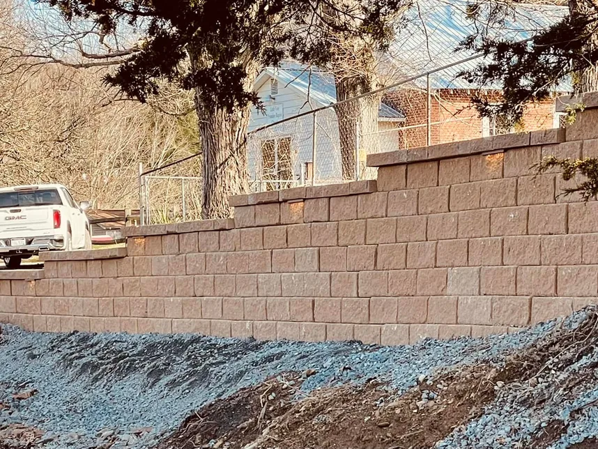 Gravel driveways: crushed stone graded along the base of a new block retaining wall