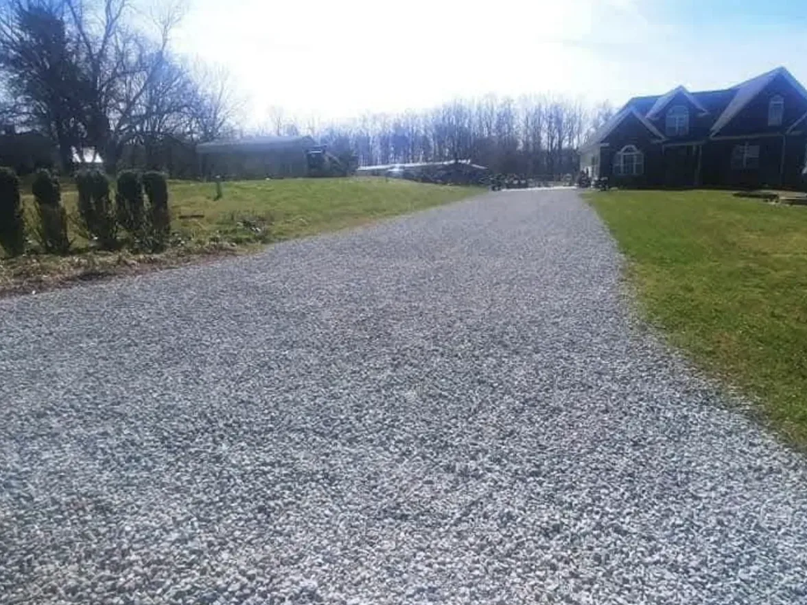 Gravel driveways: a new crushed stone driveway running up to a two story house on a rural lot