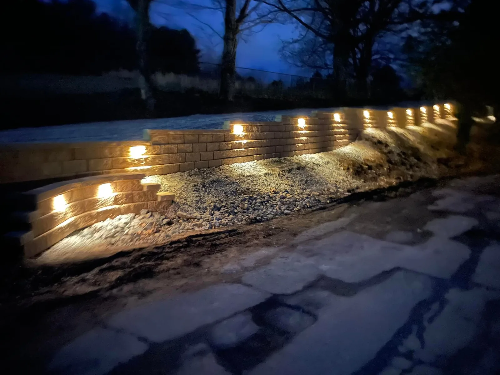 Outdoor lighting: lights set under the caps of a block wall at night