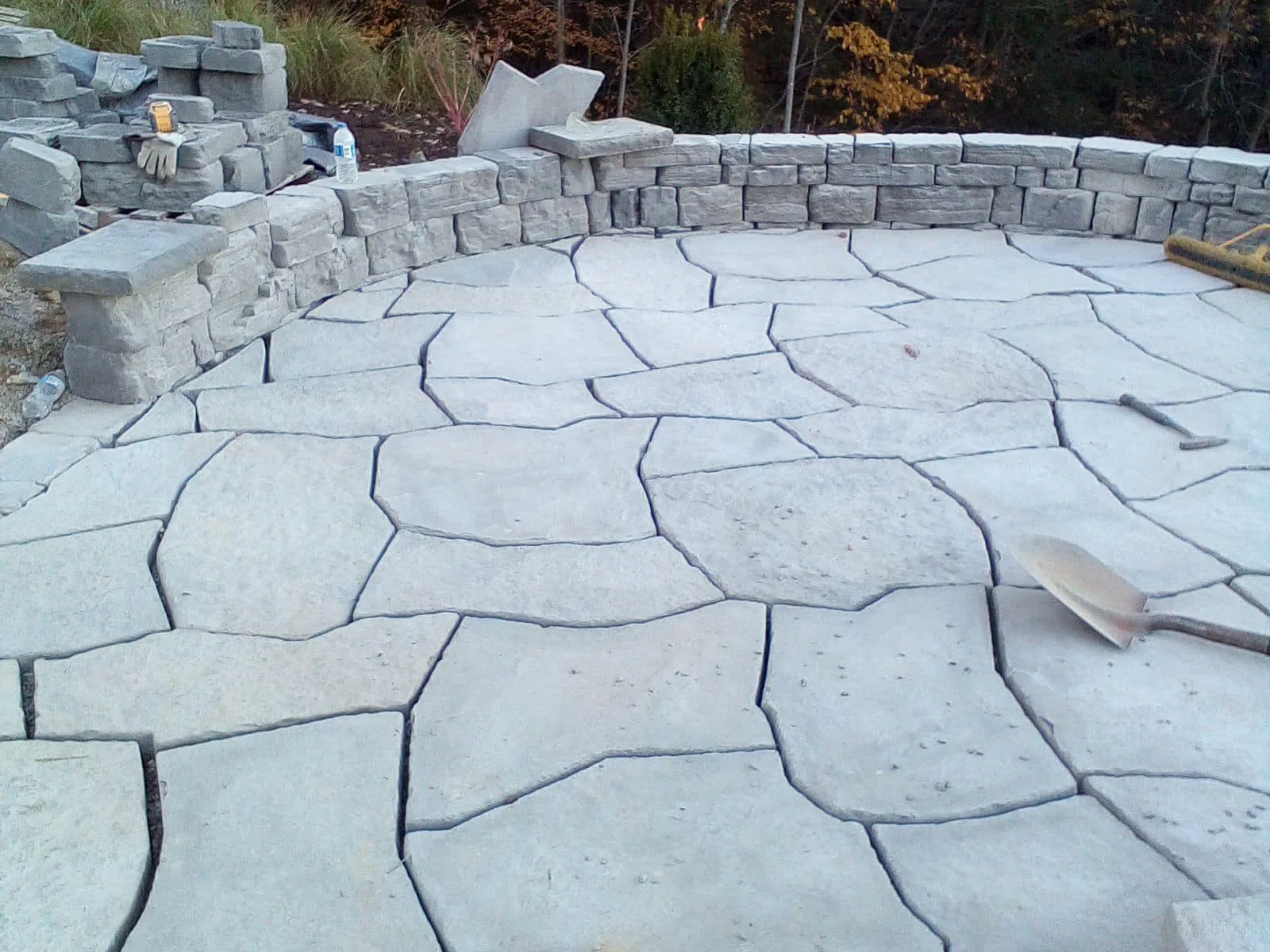 Paver patios: a wide flagstone pattern paver patio edged by a stone seating wall