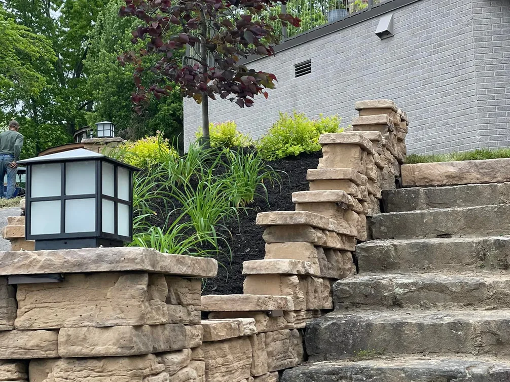 Walkways and steps: stacked stone steps climbing a slope between lantern topped pillars