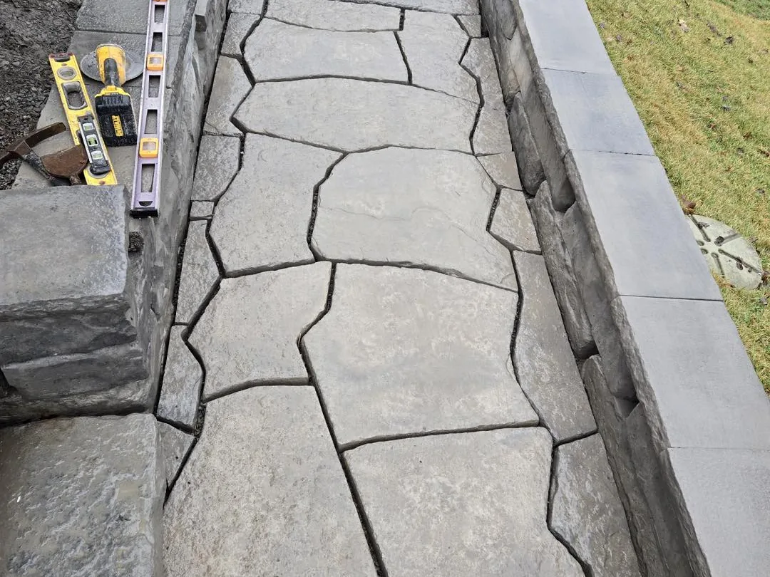 Walkways and steps: a flagstone paver walkway running beside a block wall